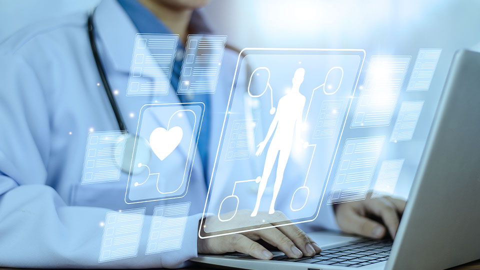 Healthcare professional on a laptop device with holographic patient charts and data.