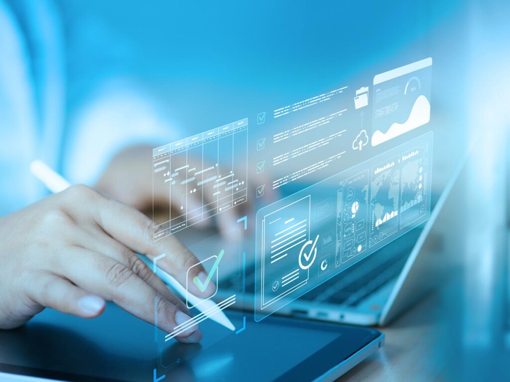 Hand using a stylus on a tablet with holographic project management charts, checklists, and analytics dashboards.
