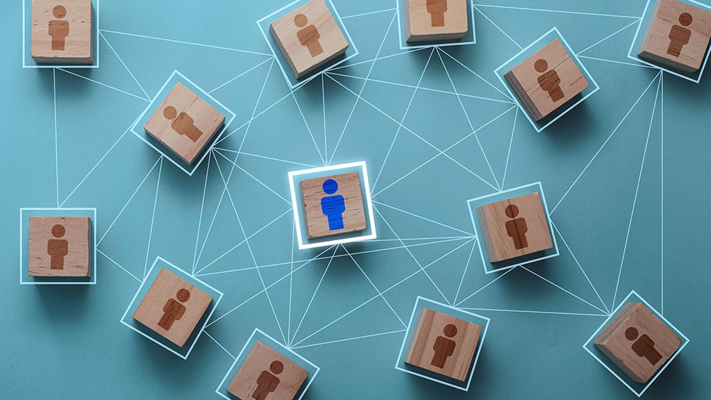 A glowing blue person icon is highlighted at the center of connected brown figure tiles on a teal background, suggesting digital networking and connection.