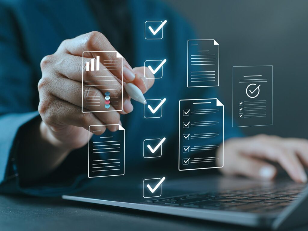 Person using a stylus near a laptop with digital icons of checklists, charts, and documents overlaid, symbolizing task completion and data review.
