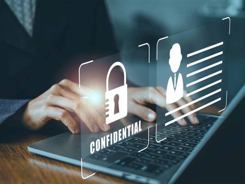 Hands typing on a laptop with digital overlays of a padlock, user profile, and “CONFIDENTIAL,” symbolizing data security.